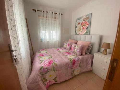 - une chambre avec un lit doté d'une couette et d'oreillers roses dans l'établissement Faneca Beach Room - Faneca Apartamentos, à Nazaré