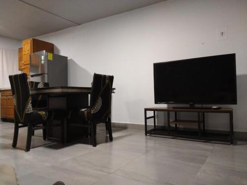 - un salon avec une télévision et une table avec des chaises dans l'établissement Casa M&J Cd. Juarez, à Ciudad Juárez