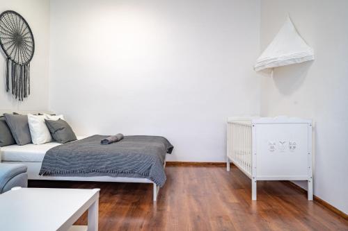 a white bedroom with a bed and a couch at FAMILY Apartment OSTRAVA in Ostrava