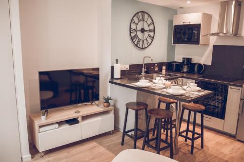 Il comprend une cuisine avec un bar avec des tabourets et une télévision. dans l'établissement LeBeauBrun_ HyperCentre_ Duplex, à Amboise