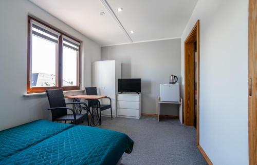 a bedroom with a bed and a table with chairs at Pensjonat Basia in Dziwnówek
