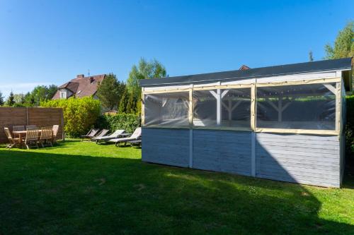 a greenhouse in a yard with a lawn at Pensjonat Basia in Dziwnówek