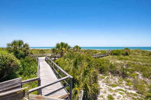 a wooden path to the beach with the ocean in the background at Sea Turtle Shores in St. Augustine