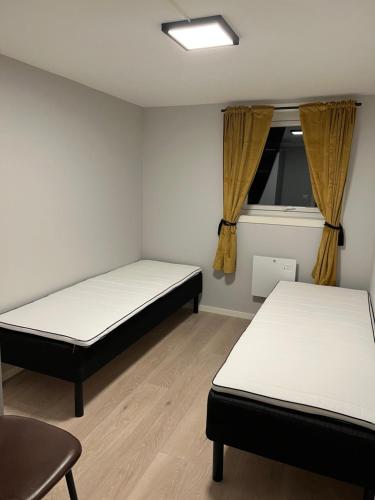 2 camas en una habitación con ventana en Atlantic Panorama Villa Kalle en Kristiansund