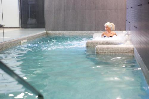 a woman in a bath tub in a swimming pool at Best Western Hotel Goldenmile Milan in Trezzano sul Naviglio