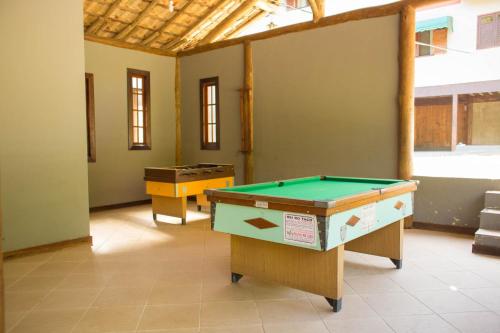 uma sala com duas mesas de pingue-pongue em Pousada Cascata em Casimiro de Abreu