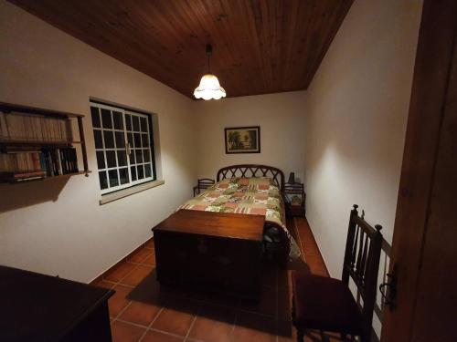 a bedroom with a bed with a table and a window at Quinta do Vale Encantado "the Valley" - Santarém - Portugal in Calhariz