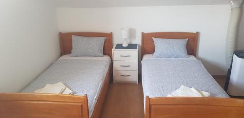 2 Betten in einem kleinen Zimmer mit Röcken in der Unterkunft Apartmani Filipi in Vrnjačka Banja