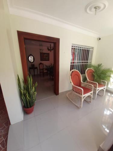 a living room with two chairs and a table at Jardines de tu sueño. in Santiago de los Caballeros