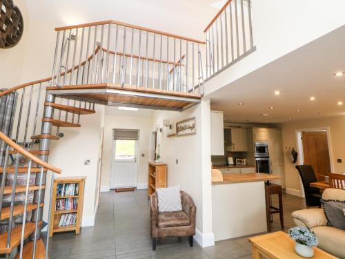 a living room and kitchen with a spiral staircase at 3 Pheasant Lane in Deepcar