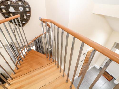 a staircase with wooden railings and a clock on the wall at 3 Pheasant Lane in Deepcar