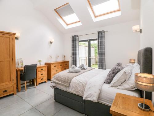 a bedroom with a bed and a desk and window at 3 Pheasant Lane in Deepcar