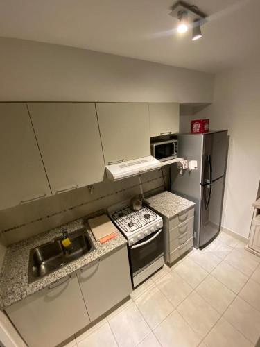 a small kitchen with a stove and a refrigerator at Excelente depto sobre Bv Galvez in Santa Fe
