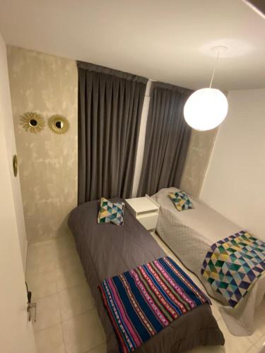1 dormitorio con 2 camas y lámpara de araña en Excelente depto sobre Bv Galvez en Santa Fe