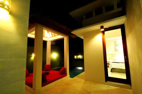 a room with a red couch and a mirror at Jas Boutique Villas in Seminyak