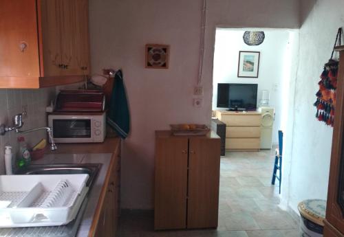 a small kitchen with a sink and a microwave at Amaryllis sweet home in Pyrgos