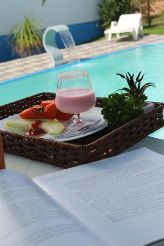 a tray of food with a drink in a basket at Pousada da Teteia in Praia Sêca