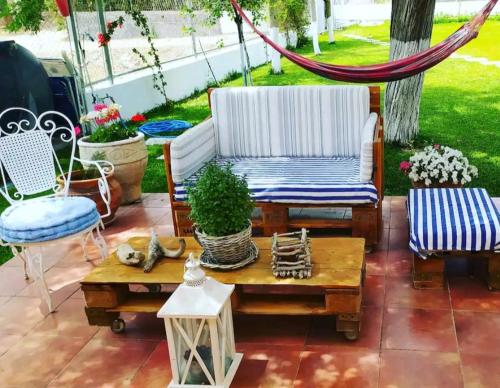 a patio with a chair and a table and a hammock at Amaryllis sweet home in Pyrgos