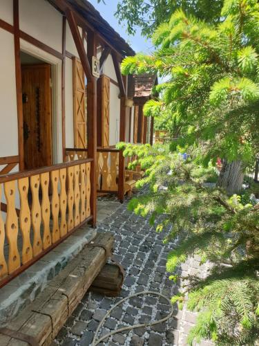 a porch of a house with a wooden fence and trees at Hnameni Stepanavan Guesthouse - Hotel in Stepʼanavan