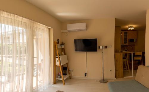 sala de estar con TV de pantalla plana en la pared en Aranypart Apartman, en Siófok