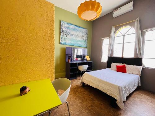 een slaapkamer met een bed en een gele muur bij Krishna Guest House in Monterrey