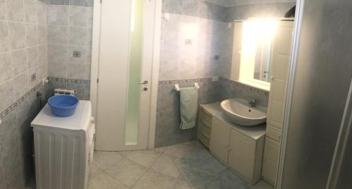 La salle de bains blanche est pourvue d'un lavabo et d'un miroir. dans l'établissement Estate Famiglia Andora, à Marina dʼAndora