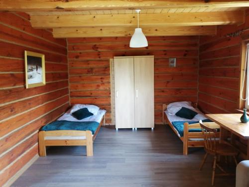 a room with two beds in a log cabin at Radawa Family Space in Radawa