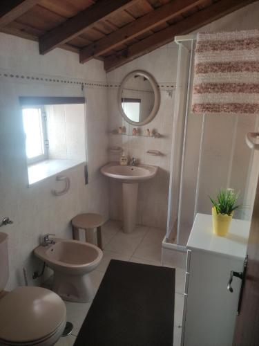 a bathroom with a sink and a toilet and a mirror at Casa da Cristina in Nazaré