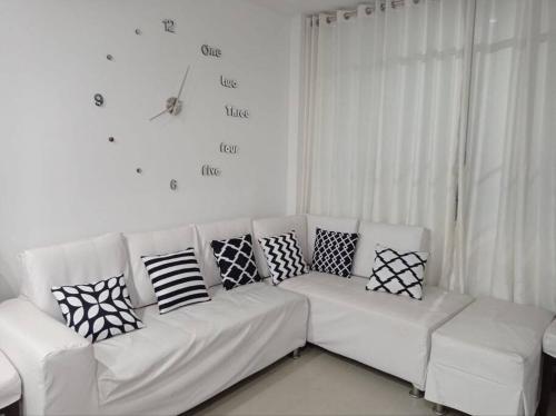 ein weißes Sofa mit Kissen darauf im Wohnzimmer in der Unterkunft Apartamento Amoblado en Tacna in Tacna