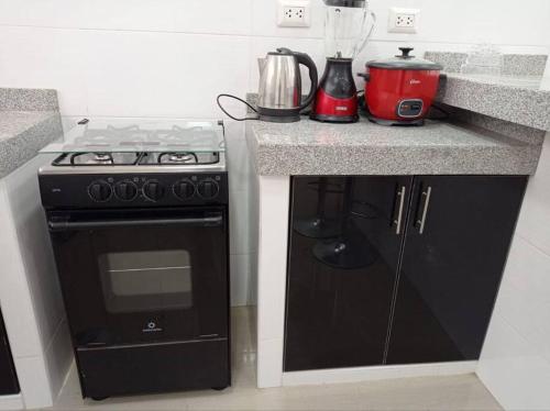 a kitchen with a black stove and a blender at Apartamento Amoblado en Tacna in Tacna
