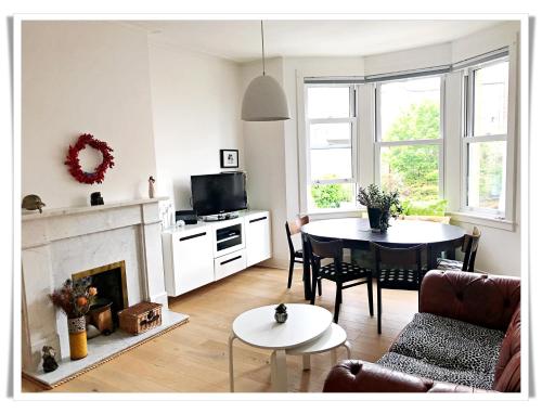 a living room with a couch a table and a fireplace at Spacious and modern 2 bedroom flat near the City Centre in Edinburgh