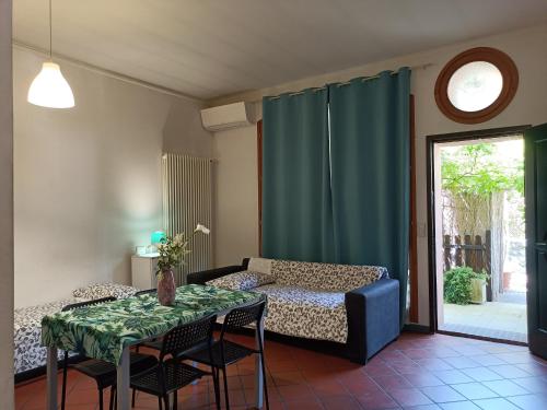 sala de estar con cama, mesa y sillas en Appartamento Borghetto San Donato, en Bolonia