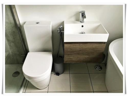 a bathroom with a white toilet and a sink at Spacious and modern 2 bedroom flat near the City Centre in Edinburgh