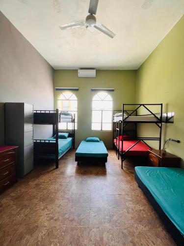 a room with four bunk beds and a ceiling fan at Barrio Antiguo Hostel HK in Monterrey