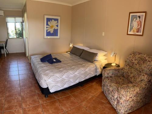 um quarto com uma cama, um sofá e uma cadeira em Childers Budget Accommodation em Childers