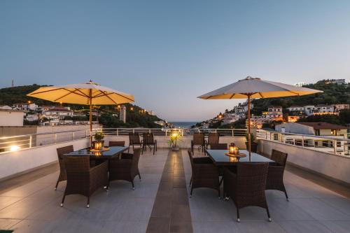 un ristorante con tavoli e ombrelloni sul tetto di Villa Oleander a Ulcinj