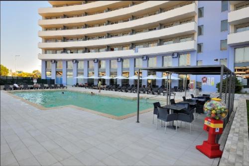 a swimming pool in front of a building at Atlantico Apartments in Portimão