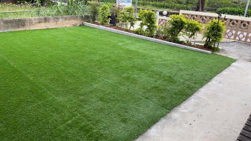 a yard with green grass in a garden at やんばる別荘三原でーじまぎー -Yanbaru stay MIHARA VILLA GRANDE- in Nago