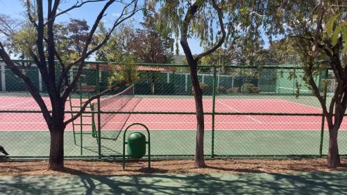 a tennis court with a net and some trees at Apartamento no Jardim botânico in Brasilia