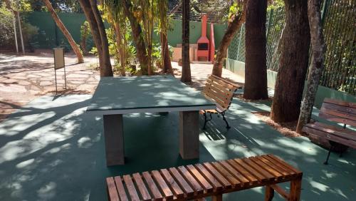 a picnic table and a bench in a park at Apartamento no Jardim botânico in Brasilia