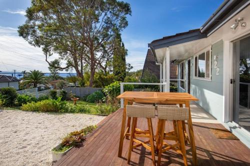 a wooden table and two chairs on a deck at WindanSea Cottage Pet Friendly Ocean Glimpses in Vincentia