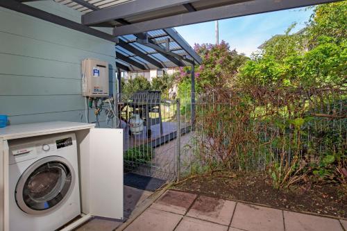 a washer and dryer in a yard with a fence at WindanSea Cottage Pet Friendly Ocean Glimpses in Vincentia