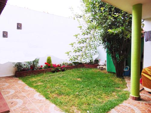 a garden in the corner of a house with a green pole at El paraíso de Zacatlán DEPARTAMENTO con JARDÍN, 11 pax in Zacatlán
