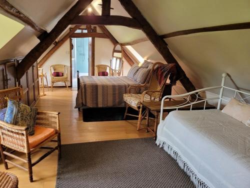 a bedroom with a bed and chairs in a attic at Gîte Martincourt, 4 pièces, 6 personnes - FR-1-526-13 in Martincourt