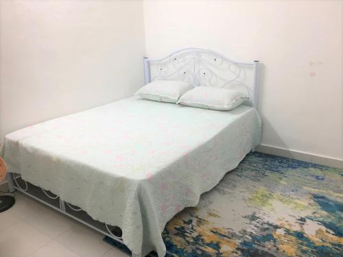 1 dormitorio con 1 cama con colcha blanca en CASA ADELIA GUESTHOUSE BALOK PERDANA GEBENG, en Kampung Saberang Balok