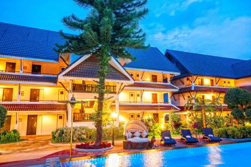 a hotel with a pool in front of it at Nak Nakara Hotel-SHA Extra Plus in Chiang Rai