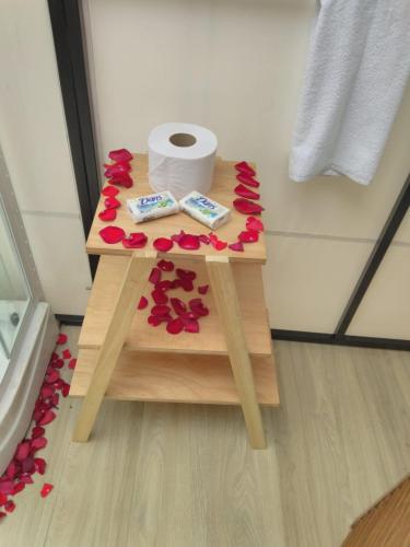 a table with red flowers on it in a bathroom at Glamping Wayra in Guatavita