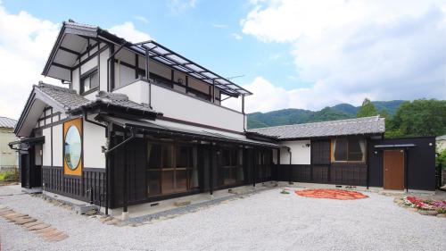 a black and white house with a driveway at 古民家ー長瀞 in Nogami