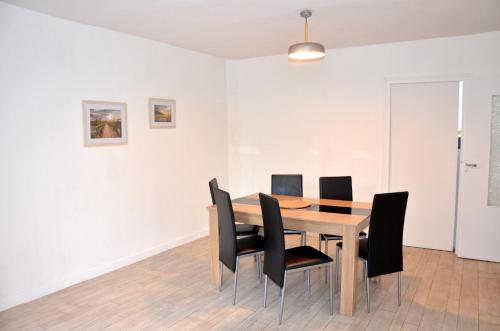 une salle à manger avec une table et des chaises noires dans l'établissement AU BORD DE L'EAU appartement 50 M2, à Chambon-sur-Voueize