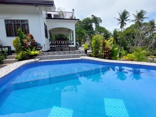 a swimming pool in front of a house at Matteo's hus VILLA RENTAL in Zamboanguita